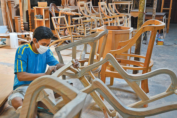 Pekerja Furnitur Di Pabrik Jepara Sedang Menghaluskan Kursi Kayu, Ilustrasi Industri Ekspor Terancam Phk